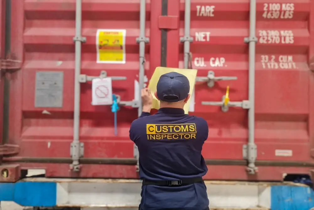 Zollbeamter prüft Ware im Container